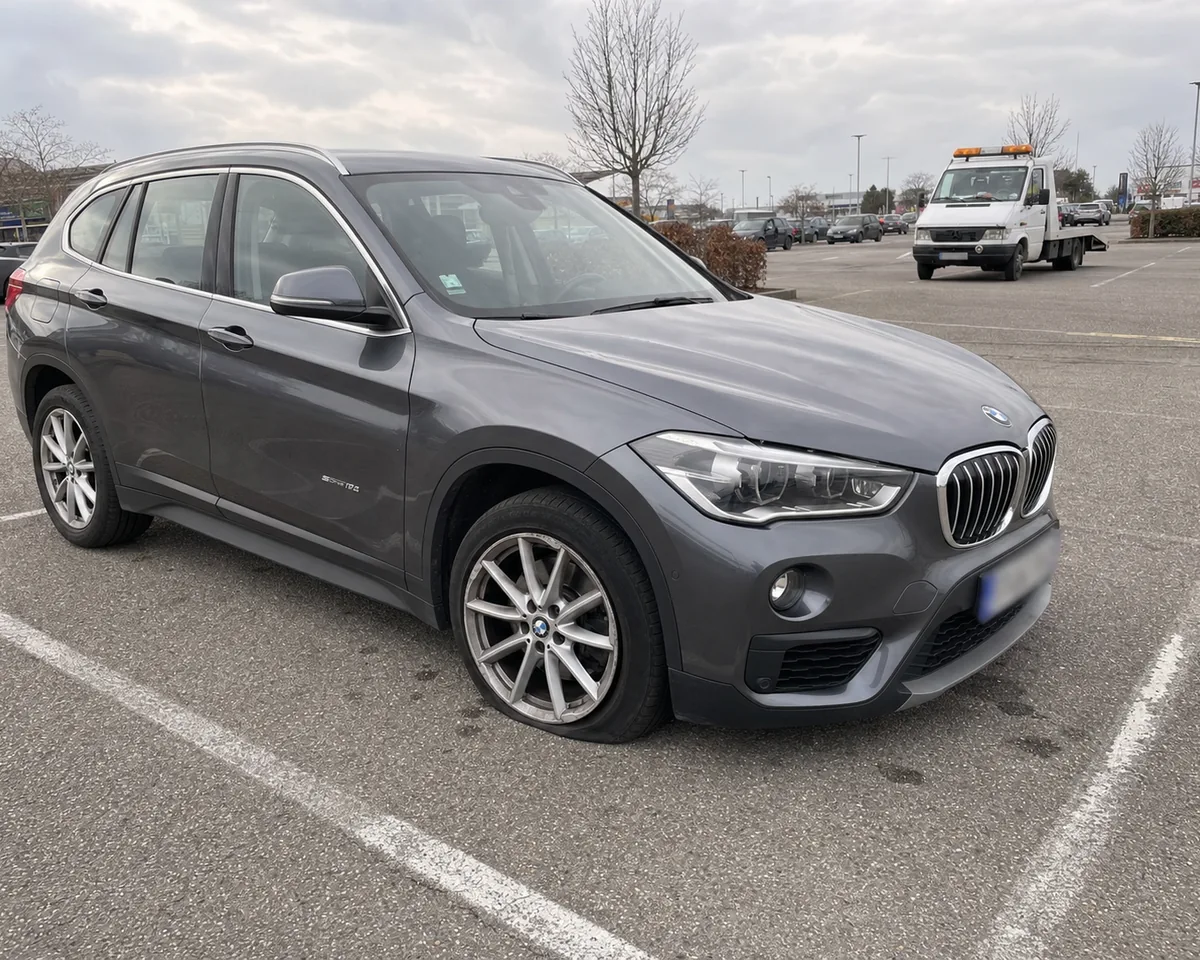 BMW X1 immobilis&eacute; avec un pneu crev&eacute;